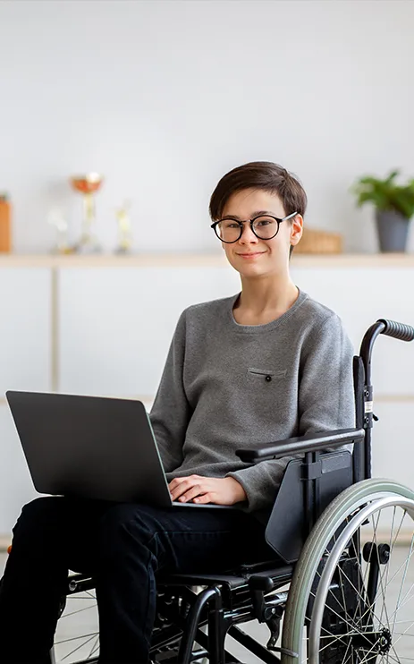 Young person in wheelchair using laptop, illustrating NDIS support services in Berwick VIC.