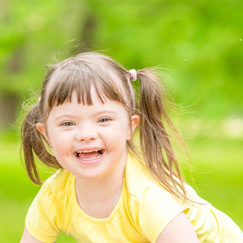 Smiling young girl outdoors enjoying playtime, representing supportive continence and disability services in Westcourt, Queensland.