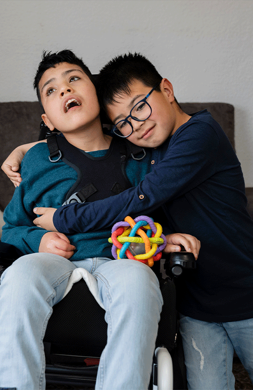 A boy in a wheelchair being lovingly embraced by his brother — children with disability in Albury, NSW supported by A1 Care Group's telehealth continence assessment service