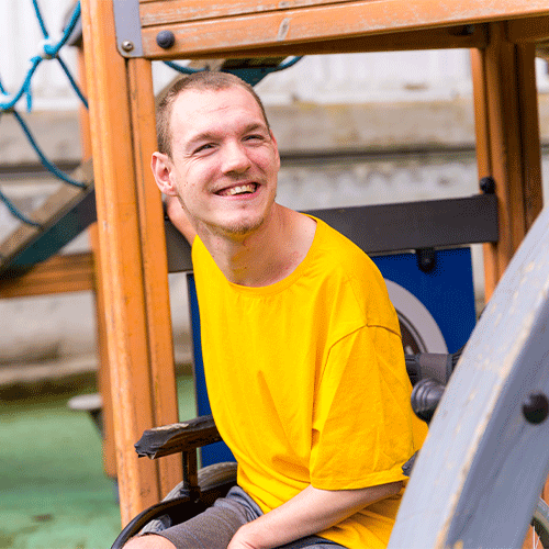 Young NDIS participant in a wheelchair smiling outdoors in Hervey Bay, QLD, supported by A1 Care Group continence assessment services