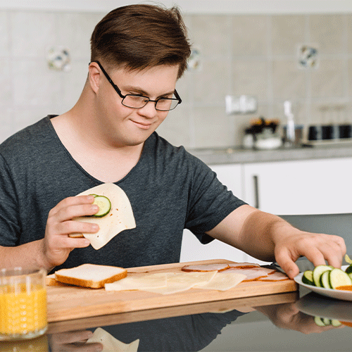 Young NDIS participant with disability preparing a healthy meal independently at home
