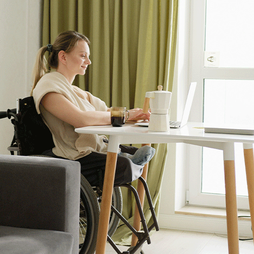NDIS participant in a wheelchair working from home, reflecting the flexibility of a telehealth continence assessment in Bundoora, VIC