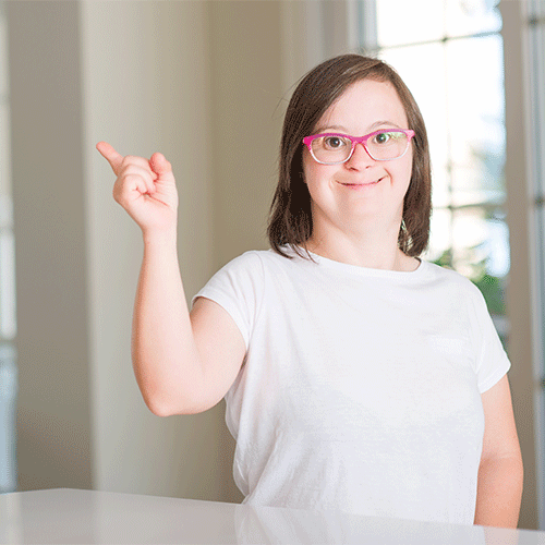 Smiling young woman with glasses pointing upward, representing NDIS participants supported by A1 Care Group